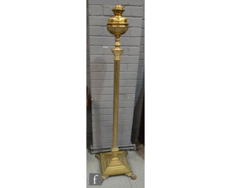 An Edwardian Corinthian column brass standard lamp on a stepped base and paw feet with reservoir, no shade, height 152cm. 