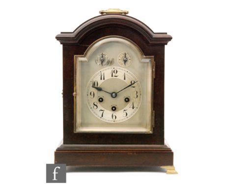 An Edwardian mahogany bracket clock with eight day chiming movement, the arched silvered dial incorporating chime/silent and 