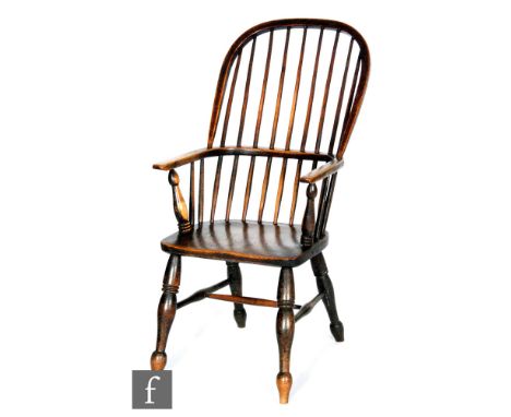 A late 19th to early 20th Century ash and elm comb back Windsor elbow chair, with saddle shaped seat over splayed legs. 