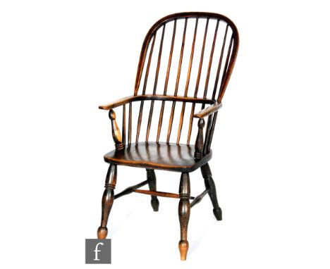 A late 19th to early 20th Century ash and elm comb back Windsor elbow chair, with saddle shaped seat over splayed legs. 