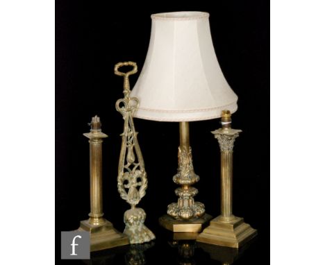 An early 20th Century brass table lamp and shade on octagonal base, height 42cm, a brass paw door stop, a Corinthian column b