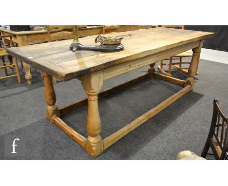 A 17th Century style light oak refectory dining table, the cleated end top on turned baluster block legs united by rail stret