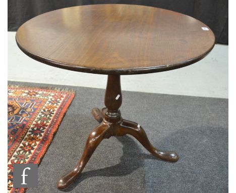 A 19th Century American walnut snap-top supper table of circular form, raised to a turned pedestal support over a tripod base