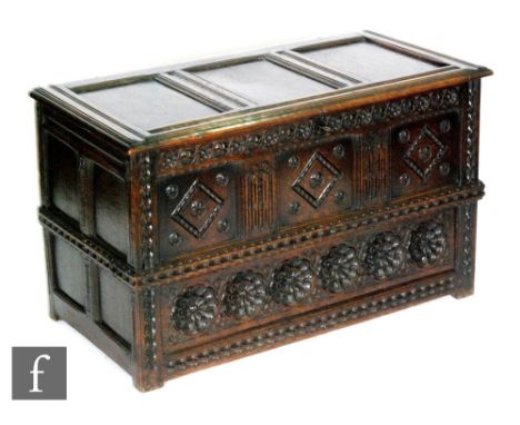 An 18th Century and later oak coffer or mule chest, the triple panelled lid over a triple fielding panel front carved with di