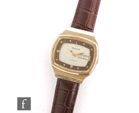 A 1970's Bulova gold plated automatic wrist watch, batons with Roman numerals and day/date facility to a cushion dial and bro