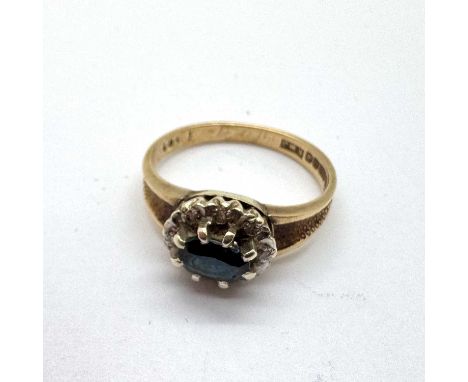 A 9ct Gold Diamond and Sapphire Set Dress Ring, the oval centre stone claw set within diamond illusion set surround, between 