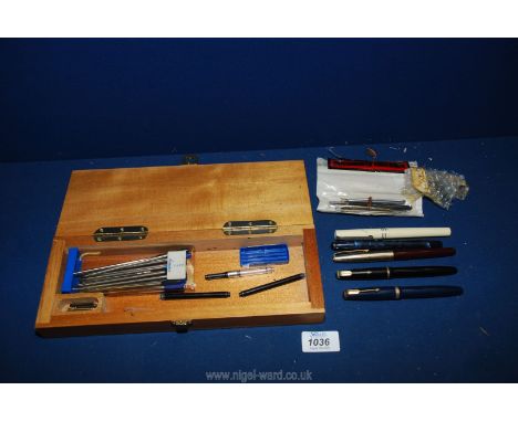 Two Parker pens with 14 k nibs, Waterman refills, Osmiroid, etc., in a wooden cribbage board/ box.