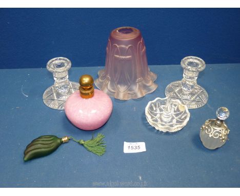 Three perfume bottles, a part dressing table set including candlesticks and ring dish, and a pink glass lamp shade.