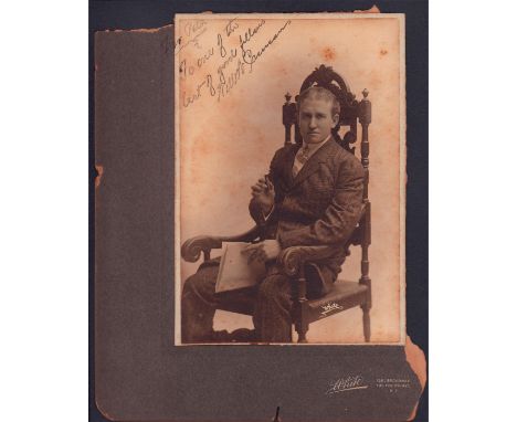 Dapper portrait of a man with middle part holding a cigar and paper while seated in chair. Albumen print on cardstock.Legible