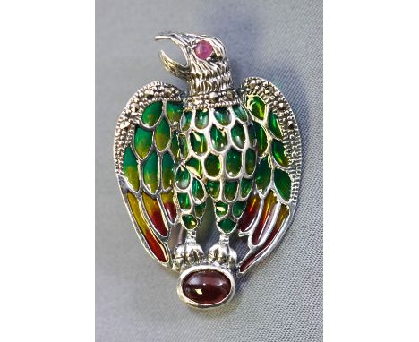 A white metal abstract eagle brooch. Set with an oval cabochon cut ruby together with a ruby set eye and marcasite set wings.