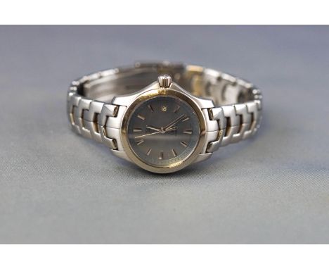 A stainless steel Tag Heuer Link wristwatch. Blue mother of pearl dial with baton markings and date feature. Quartz movement.