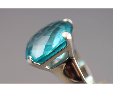 A rhodium plated dress ring by Swarovski. Having a large faceted blue Swarovski crystal. Supplied with original box and certi