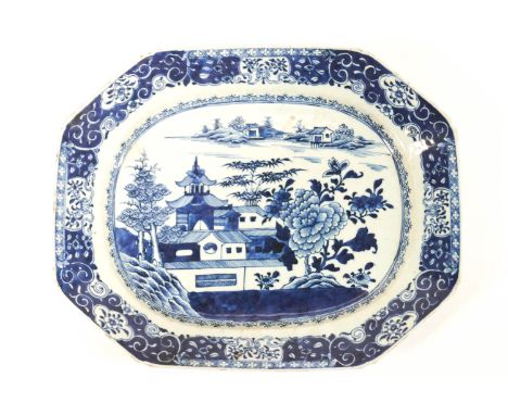 An octagonal Chinese porcelain export plate, painted in blue with a scene of a house and peonies in a landscape, in a floral 