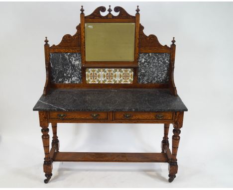 A 19th century pitch pine wash stand with decorative shaped back with broken pediment above a square mirror and tile motif an