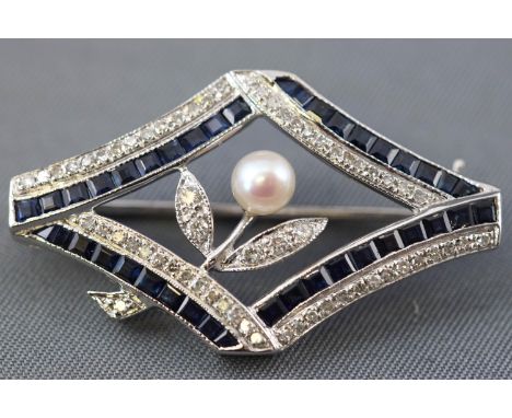 A white metal abstract design brooch set with calibre cut sapphires and single/brilliant cut diamonds and finished with a cul