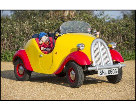 A 1977 Reliant Kitten DL road legal Noddy car construction, registration number SHL 660S, red and yellow.  This faithful repr