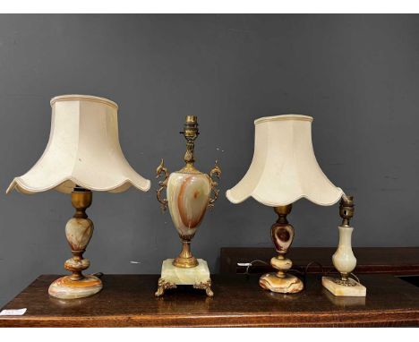 Four onyx table lamps, 20th century, to include a baluster shaped lamp with gilt metal mounts and scrolled bird twin handles 
