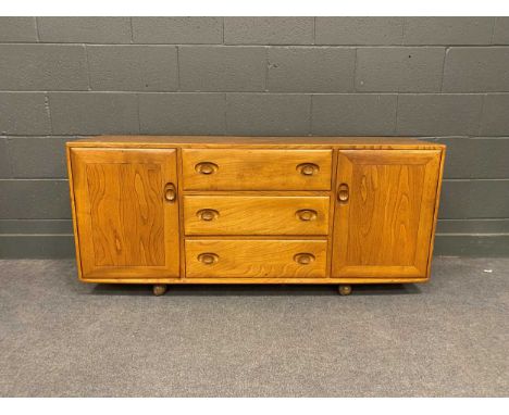 An Ercol type stained elm sideboard with three central drawers flanked by cupboards 69cm x 155.5cm 43cm
