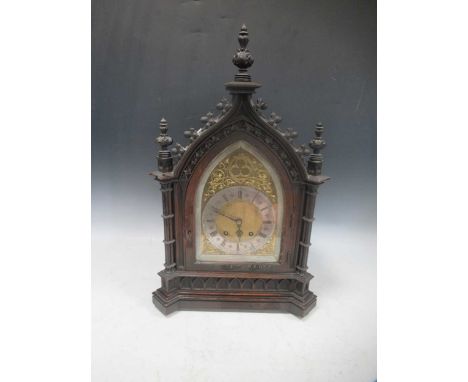 A late Victorian ebonised striking mantel clock in the Gothic style, with arched brass dial, silvered chapter ring, and Germa