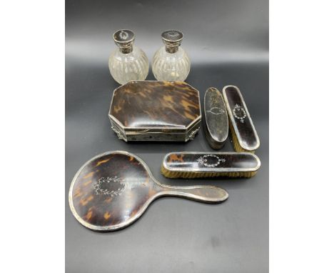 A silver and tortoiseshell mounted dressing table set, hallmarked Birmingham 1919, comprising two brushes, two bottles, hand 