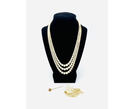 A three strand pearl necklace; a costume jewellery pearl brooch; a gold coloured stick pin with small diamond to centre Estim