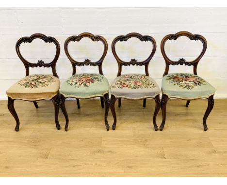 Four Victorian mahogany balloon back dining chairs, with carved detail to back on cabriole legs with tapestry upholstered sea