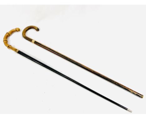 A black lacquer walking stick with 9ct rolled gold band and bamboo handle, together with a walking stick with 9ct rolled gold