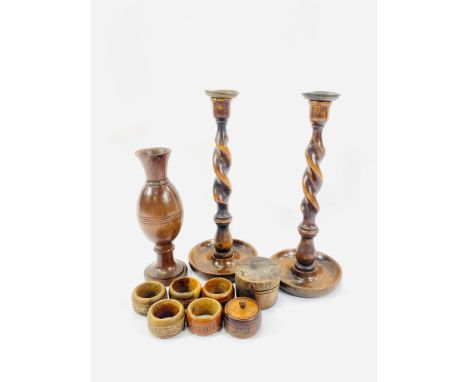 A pair of oak barley twist candlesticks, 30cm; a turned wood vase, 22cm; two lidded wood pots; five wood napkin rings. Estima