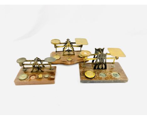 Three mahogany and brass letter scales with various weights. Estimate: £15-30