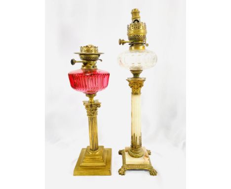 A Victorian brass column oil lamp with cranberry glass reservoir, 50cm; a Victorian oil lamp with onyx column support, brass 