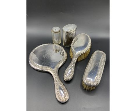 A silver mounted dressing table set, hallmarked Birmingham 1907, comprising hand mirror, two brushes and two lidded jars. Est