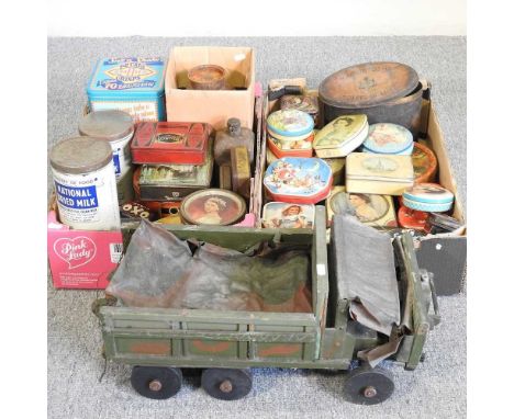 A painted toy army truck, 55cm long, together with vintage advertising tins