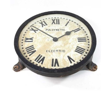 A cast iron Pulsynetic electric wall clock, 34cm diameterLooks to be complete, but discoloured, heavily weathered and dirty. 