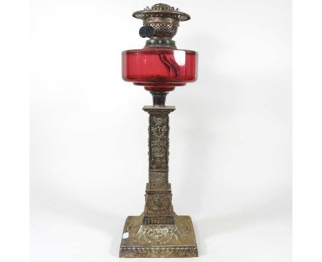 An early 20th century silver plated oil lamp, with a cranberry glass font, 50cm highOverall looks to be complete but dirty. D