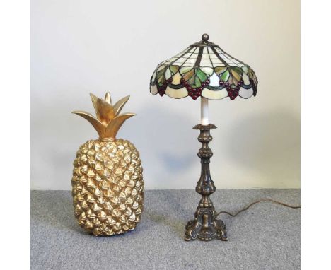 A gilt painted pineapple, together with a Tiffany style table lamp, 70cm high (2)Shade is cracked on the edge