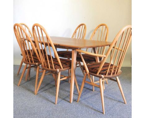 A 1970's Ercol light elm dining table, together with a set of six matching high back dining chairs, with original cushions (7
