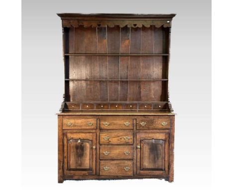 An 18th century style oak dresser, the boarded back with spice drawers, over an arrangement of six drawers, flanked by cupboa