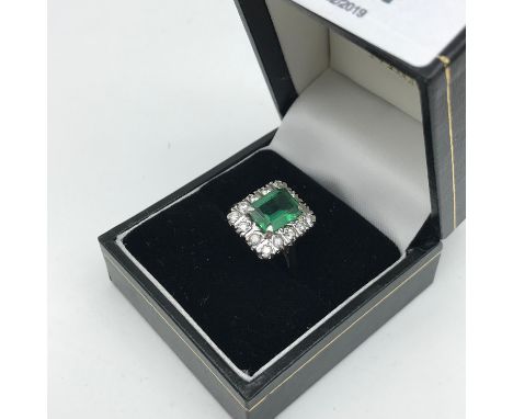 A 9ct gold ladies dress ring set in a square design, Centred with a large green stone squared off with cz stones. 