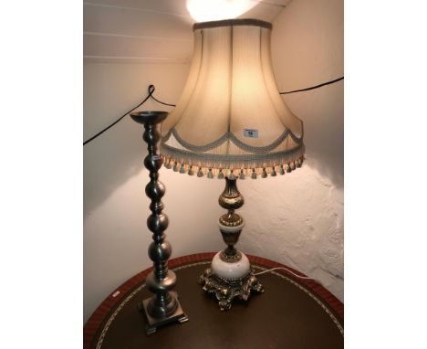 An ornate onyx and metal table lamp together with a large single candle stick. 