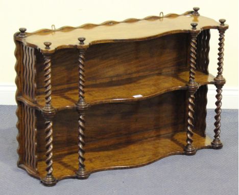 A mid-Victorian oak three-tier hanging wall shelf of serpentine form, with carved barley twist supports and pierced sides, he