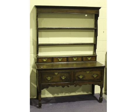 An 18th Century and later oak dresser, the shelf back above four small drawers and two deep frieze drawers, all with crossban