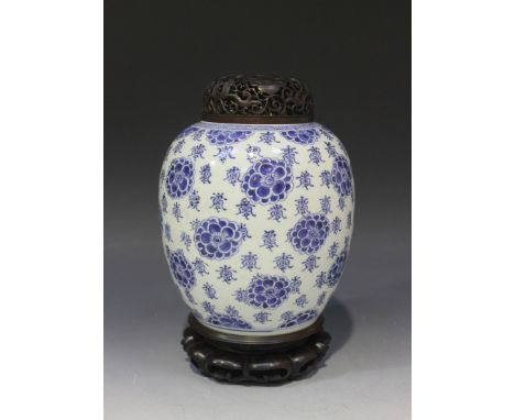 A Chinese blue and white porcelain ginger jar, Kangxi period, the ovoid body painted with flowerheads and characters, undergl