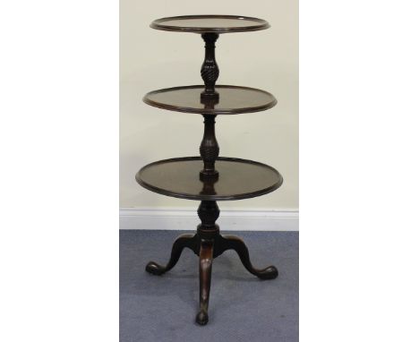A George III mahogany circular three-tier graduated dumb waiter with chequer stringing, raised on a turned and reeded baluste