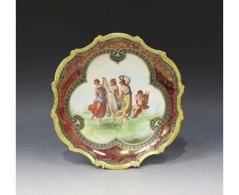 A Vienna style porcelain dish, the centre decorated with three maidens dancing accompanied by a cherub playing a lyre, within