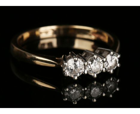 A 9ct gold and diamond three stone ring, claw set with a row of circular cut diamonds, ring size approx O, with a case.