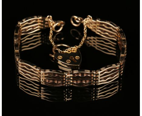 A 9ct gold bar and curved bar link gate bracelet on a 9ct gold heart shaped padlock clasp.
