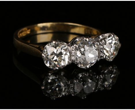 An 18ct gold and diamond three stone ring, claw set with a row of cushion shaped diamonds, ring size approx L1/2, with a case