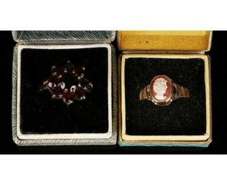 A 9ct gold and garnet set nine stone cluster ring, a 9ct gold and oval shell cameo ring, carved as the portrait of a lady, a 