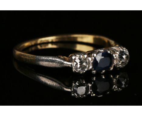 A gold, platinum, sapphire and diamond three stone ring, mounted with the oval cut sapphire between two cushion shaped diamon