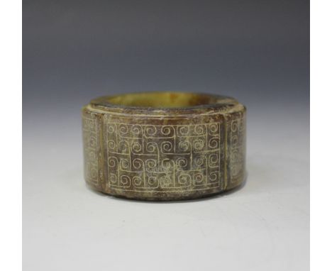 A Chinese archaistic jade ring, probably 20th Century, the stone of mottled green and brown tone, incised with a band of arch